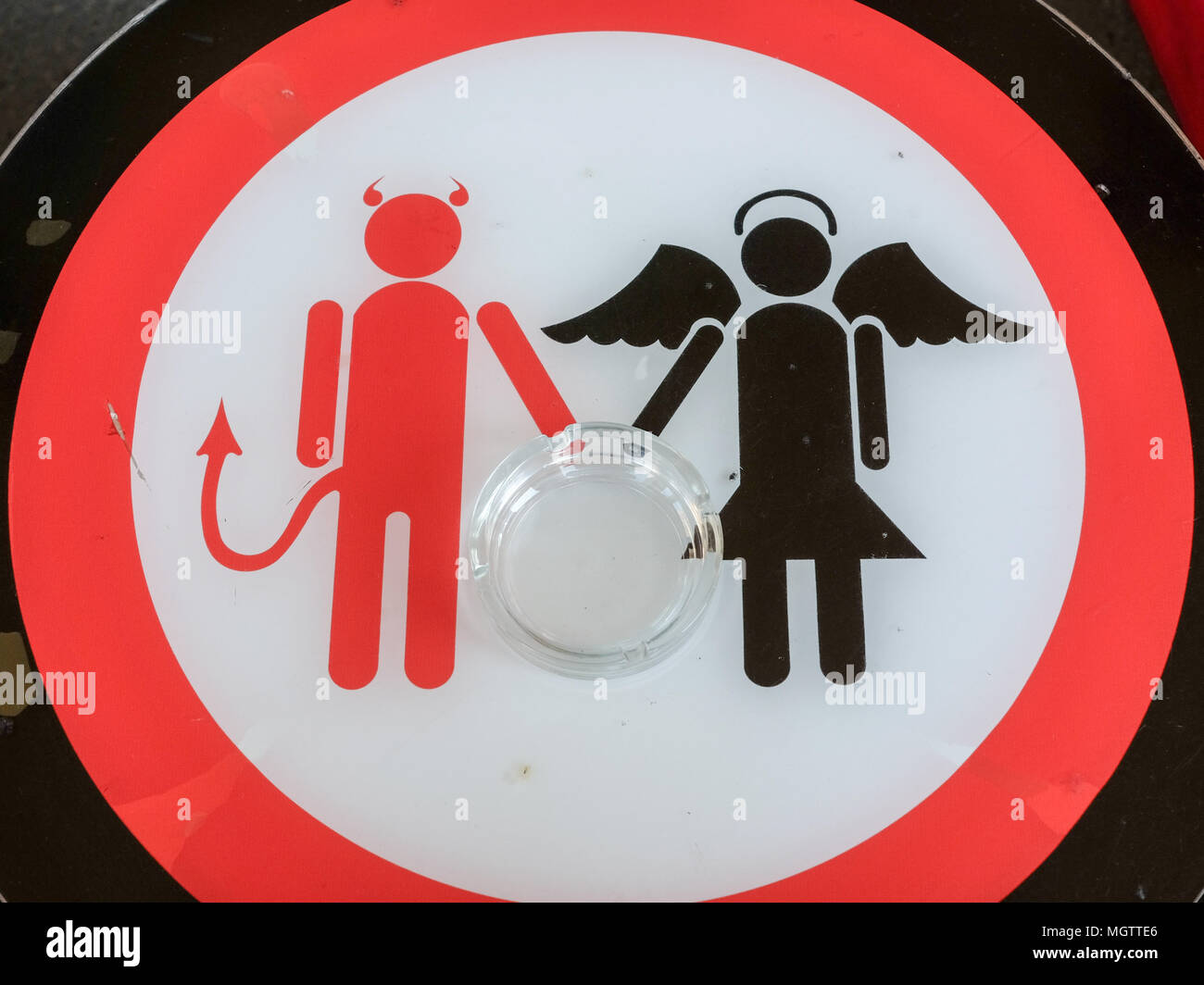 23 April 2018, Budapest, Germany: An angel and a devil are depicted on a table with an ashtray on it. Photo: Jens Kalaene/dpa-Zentralbild/ZB Stock Photo