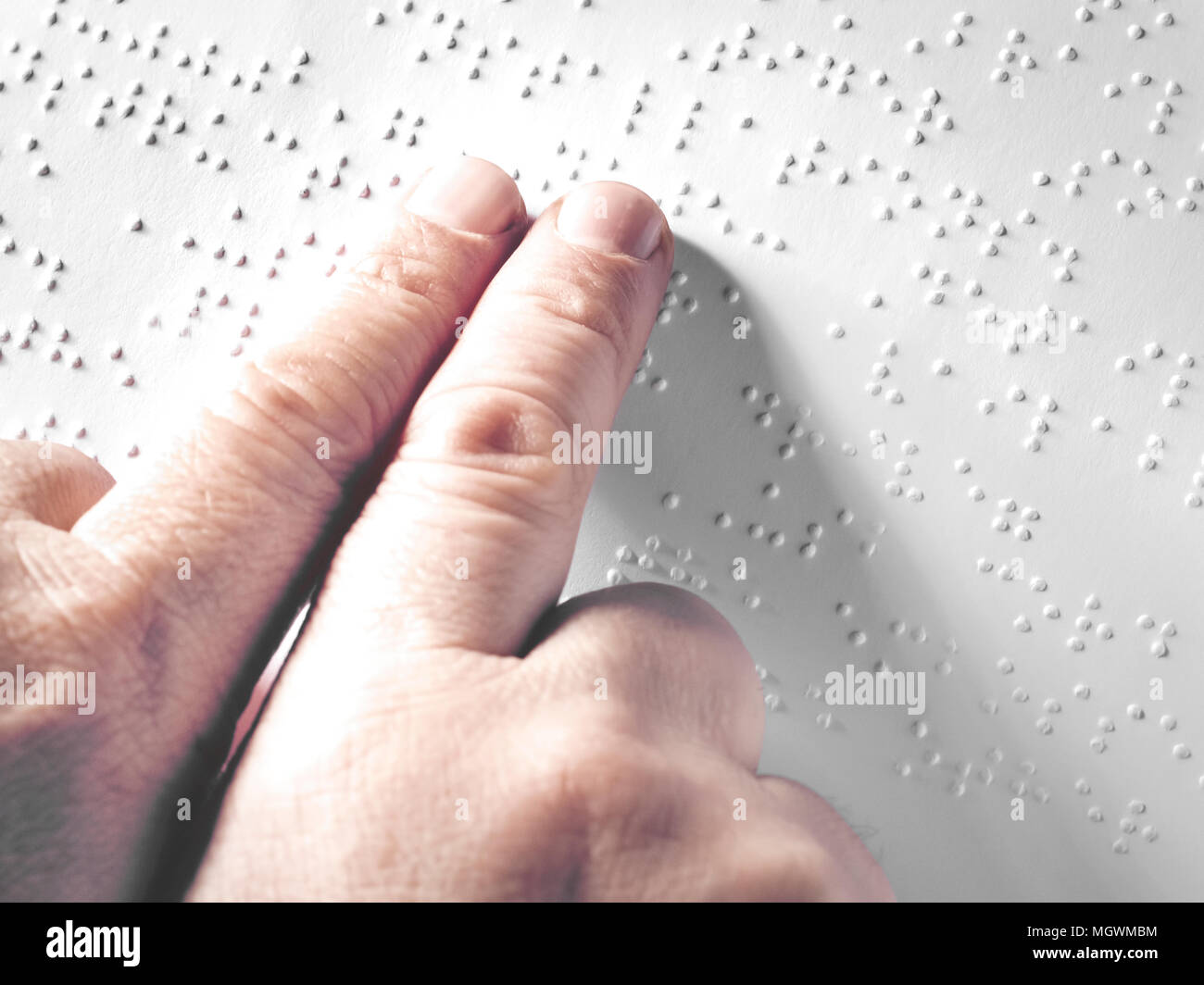Hands of a blind person reading some braille text touching the relief. Horizontal Stock Photo