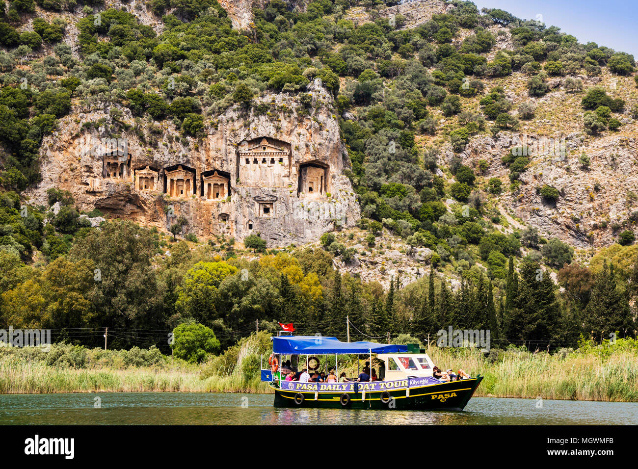 river-boat-with-tourists-on-the-river-dalyan-by-the-sheer-cliffs-with