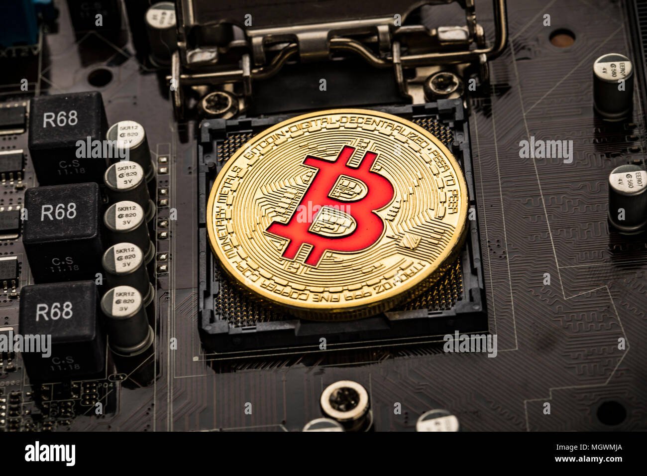 Gold Bit Coin BTC coins on the motherboard. Bitcoin is a worldwide cryptocurrency and digital payment system called the first decentralized digital cu Stock Photo