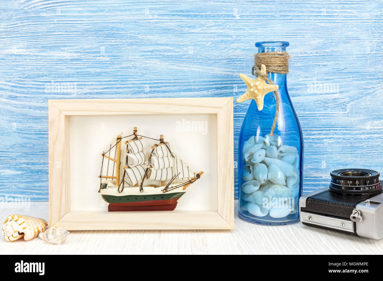 travel and vacation background. photo frame with ship, camera and marine items on wooden table  Stock Photo