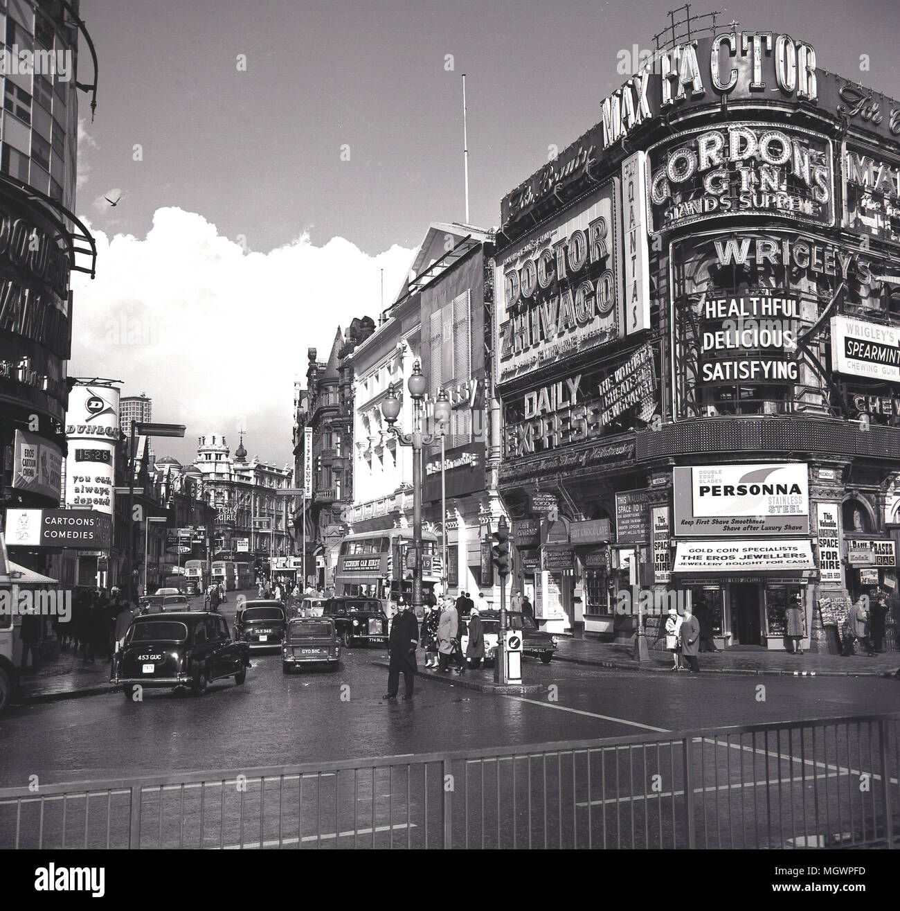 1966, historical picture showing a view up Shaftesbury Avenue at Piccadilly Circus, with advertising billboards for famous brands, Max Factor, Wrigley's and The Daily Express. Also advertised is the film, Doctor Zhivago staring Omar Sharif and Julie Christie and directed by David Lean, London, England, UK. Stock Photo
