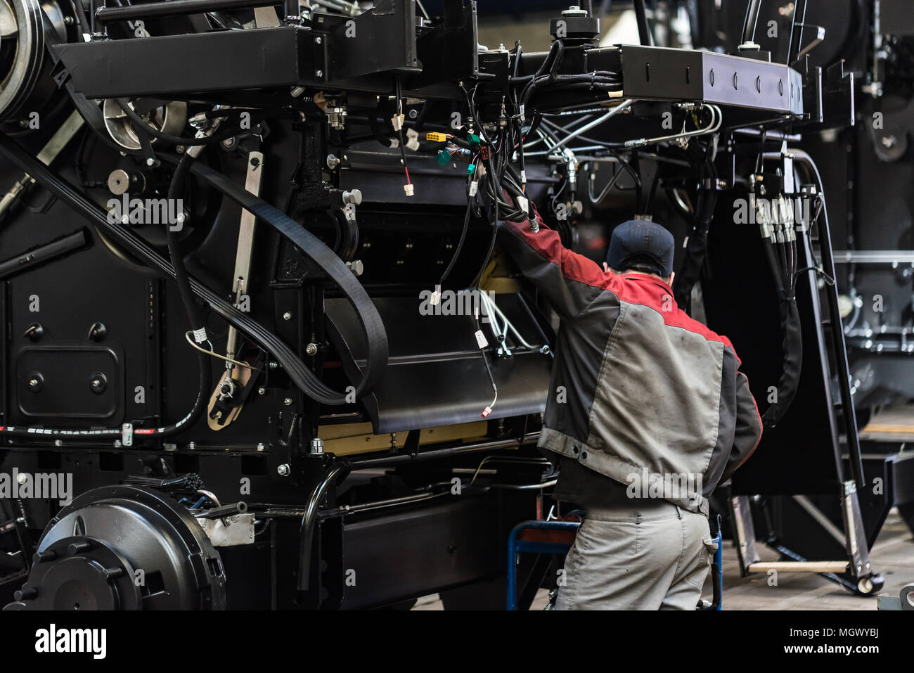 Industrial worker assembles agricultural equipment Stock Photo