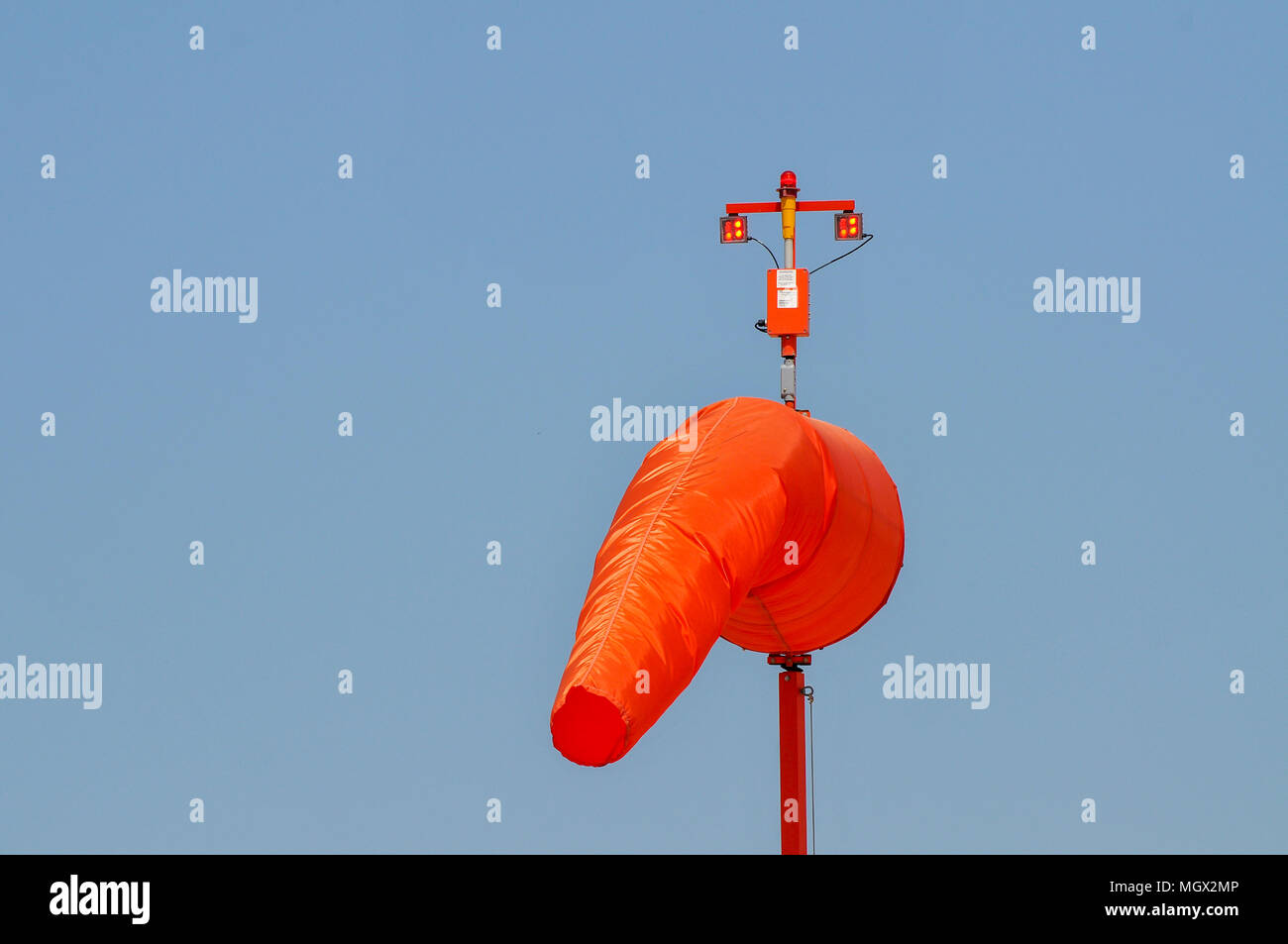 Orange Windsock on a blue sky background Photographed in an airfield in