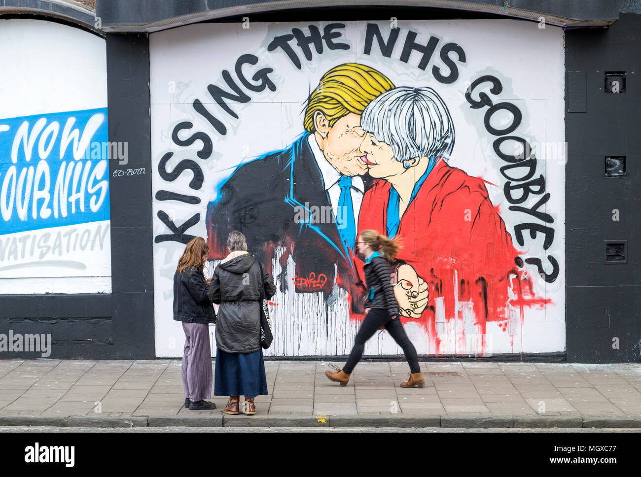 Bristol, UK. 24/02/17 Street art warning about the death of the NHS depicting Prime Minister May + President Trump kissing is pictured in Stokes Croft Stock Photo