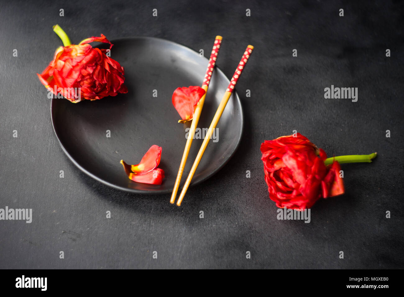 Summer table setting decorated with Red Princess tulips on rustic background Stock Photo