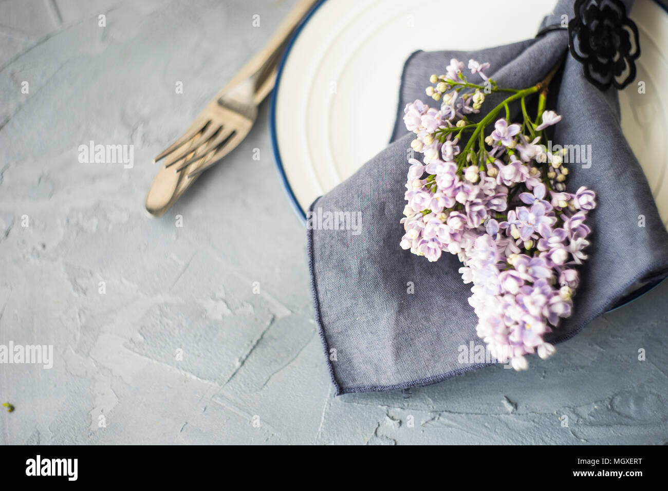Spring table setting with lilac flowers on rustic table with copy space ...