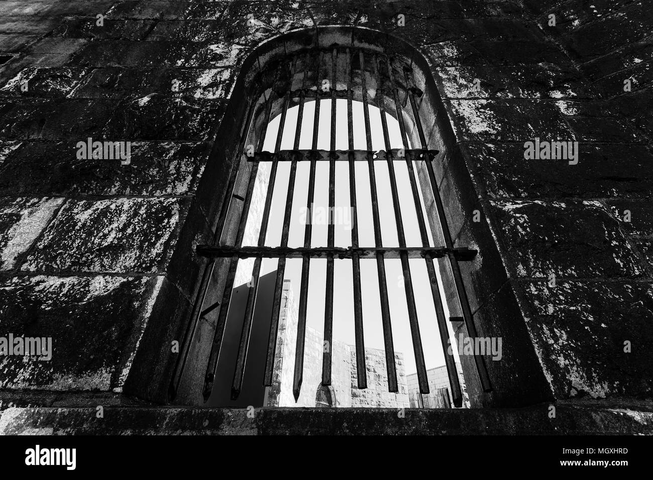 Steel bars on windows in stone brick wall of Trial bay gaol ruins as museum of australian colonial past and heritage. Black-white impression of impris Stock Photo