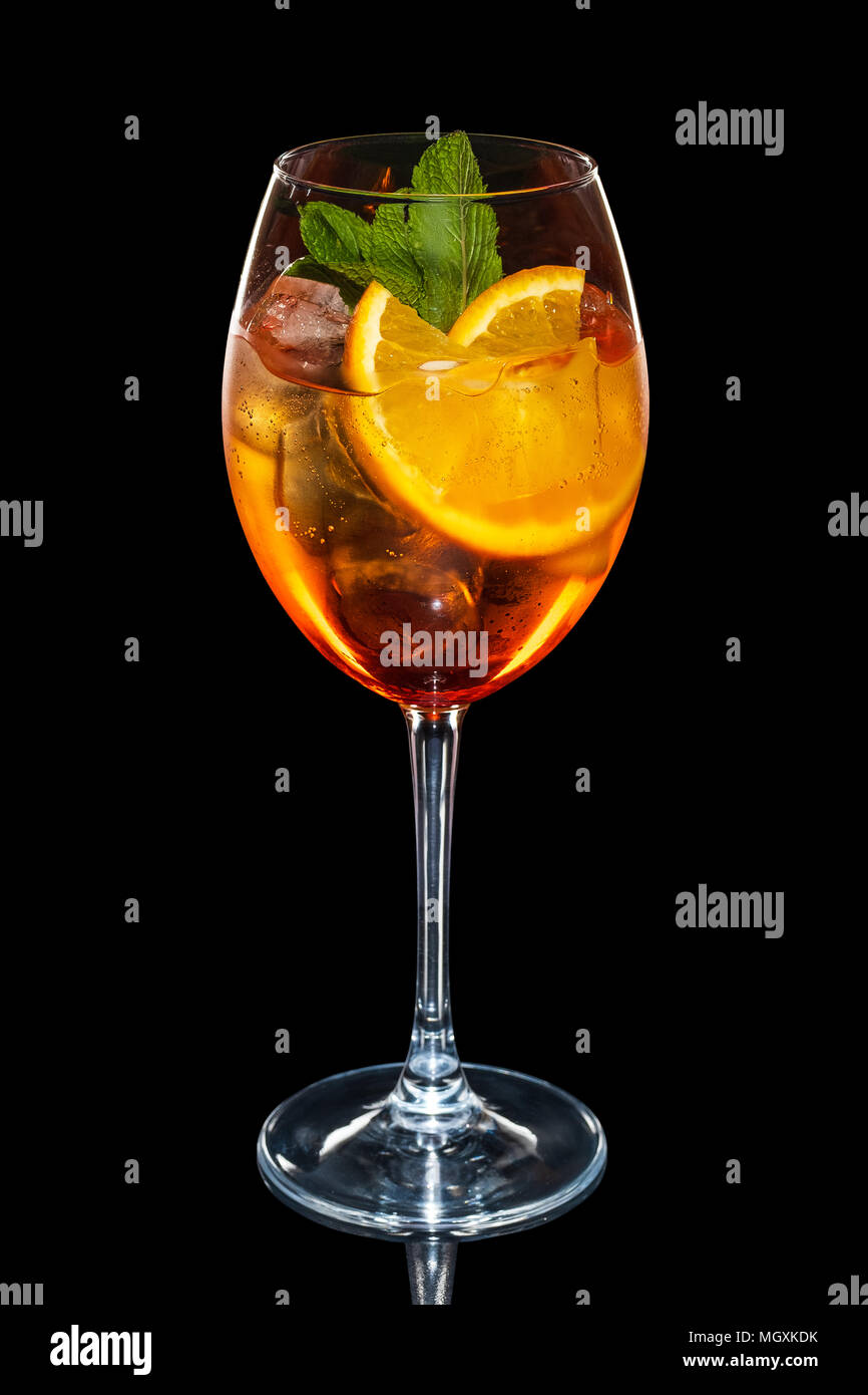 Cherry and orange cocktail with ice cubes in wine glass isolated on black Stock Photo