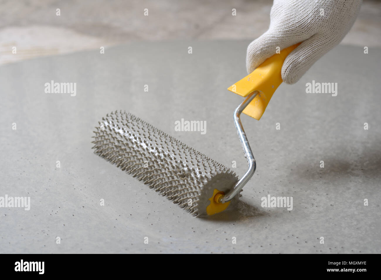 Leveling the floor using spiked roller Stock Photo