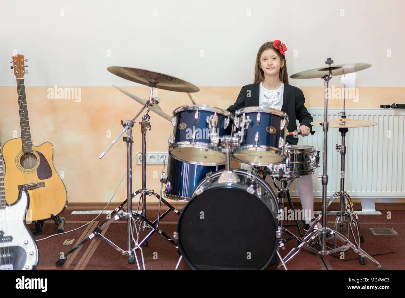 young caucasian teenage girl plays the drums. girl playing the drum set