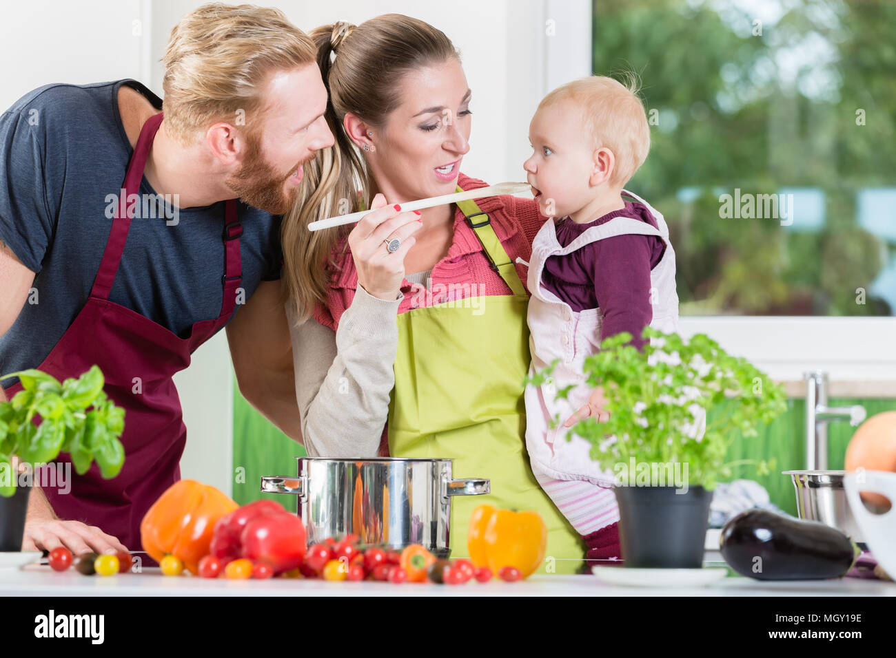 Mom, dad and child in kitchen Stock Photo