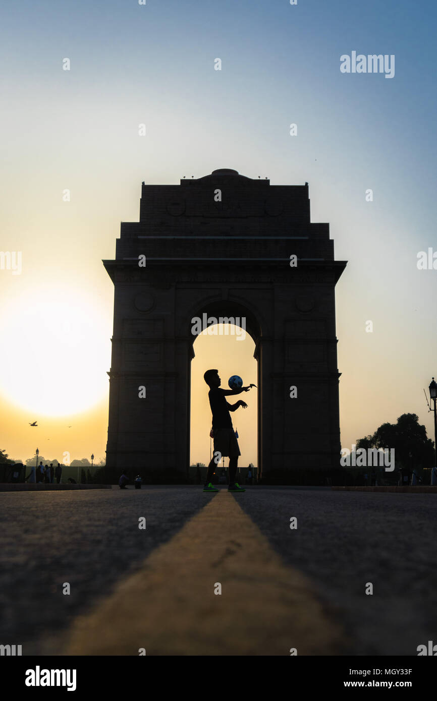Freestyle football juggling at India Gate during sunrise with flying birds in New Delhi Stock Photo