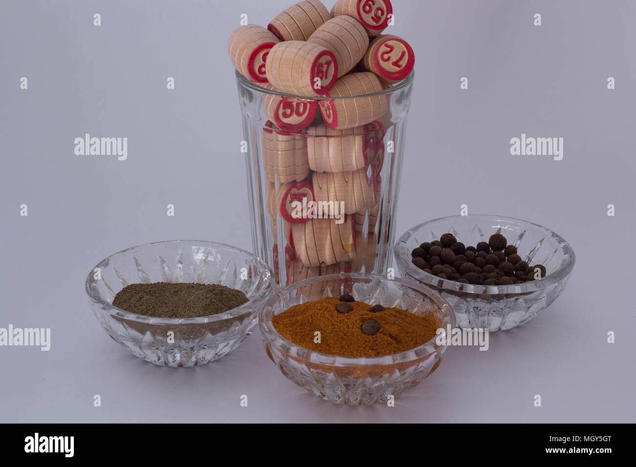 Ground pepper in the saucers is next to the kegs of lotto in a faceted glass Stock Photo