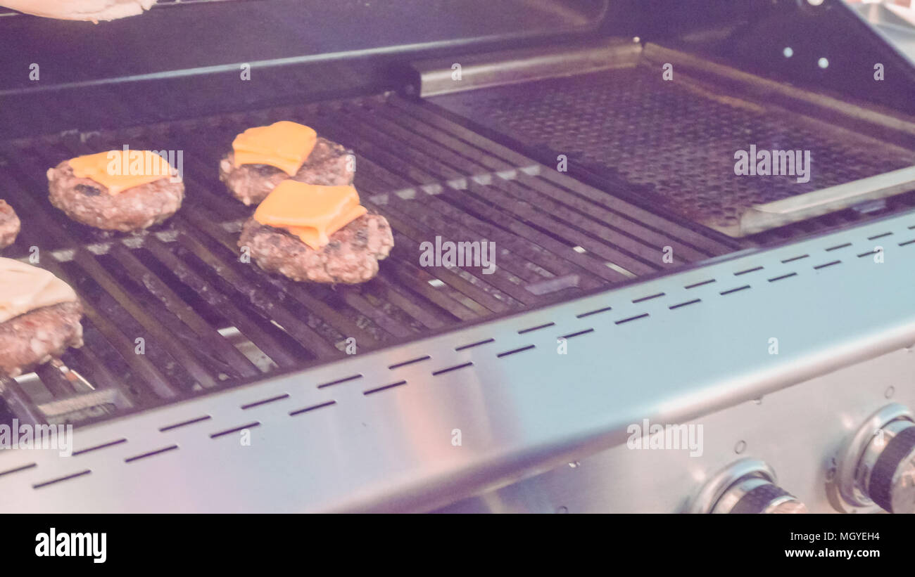 Cooking classic beef burger on outdoor gas grill Stock Photo Alamy