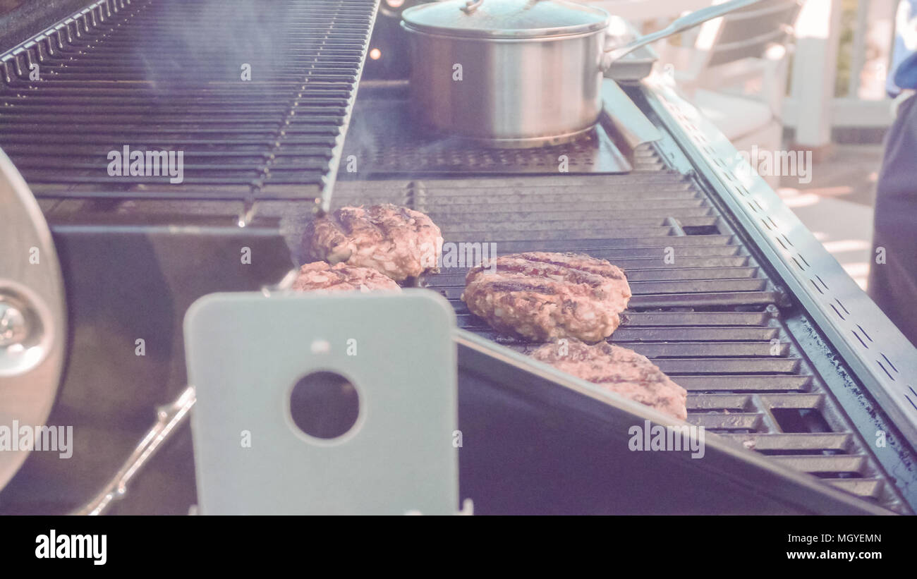 Cooking classic beef burger on outdoor gas grill Stock Photo Alamy