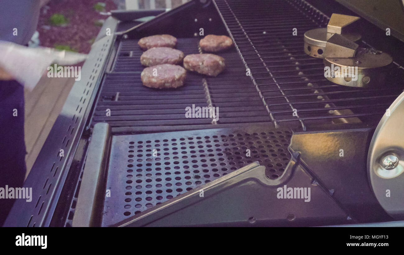 Cooking classic beef burger on outdoor gas grill Stock Photo Alamy