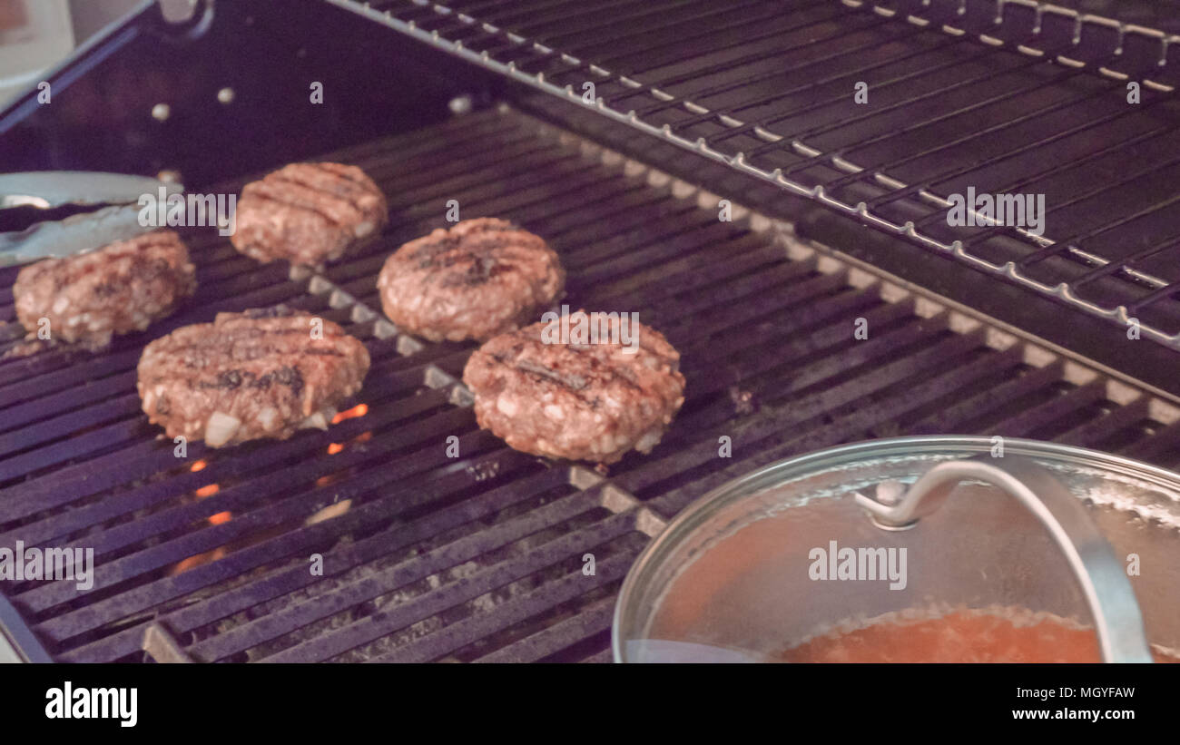 Cooking classic beef burger on outdoor gas grill Stock Photo Alamy