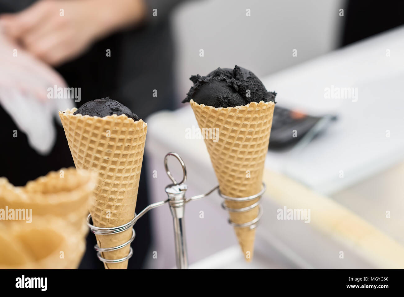 Trendy and popular delicacies for adults and children. Soft black ice cream in traditional