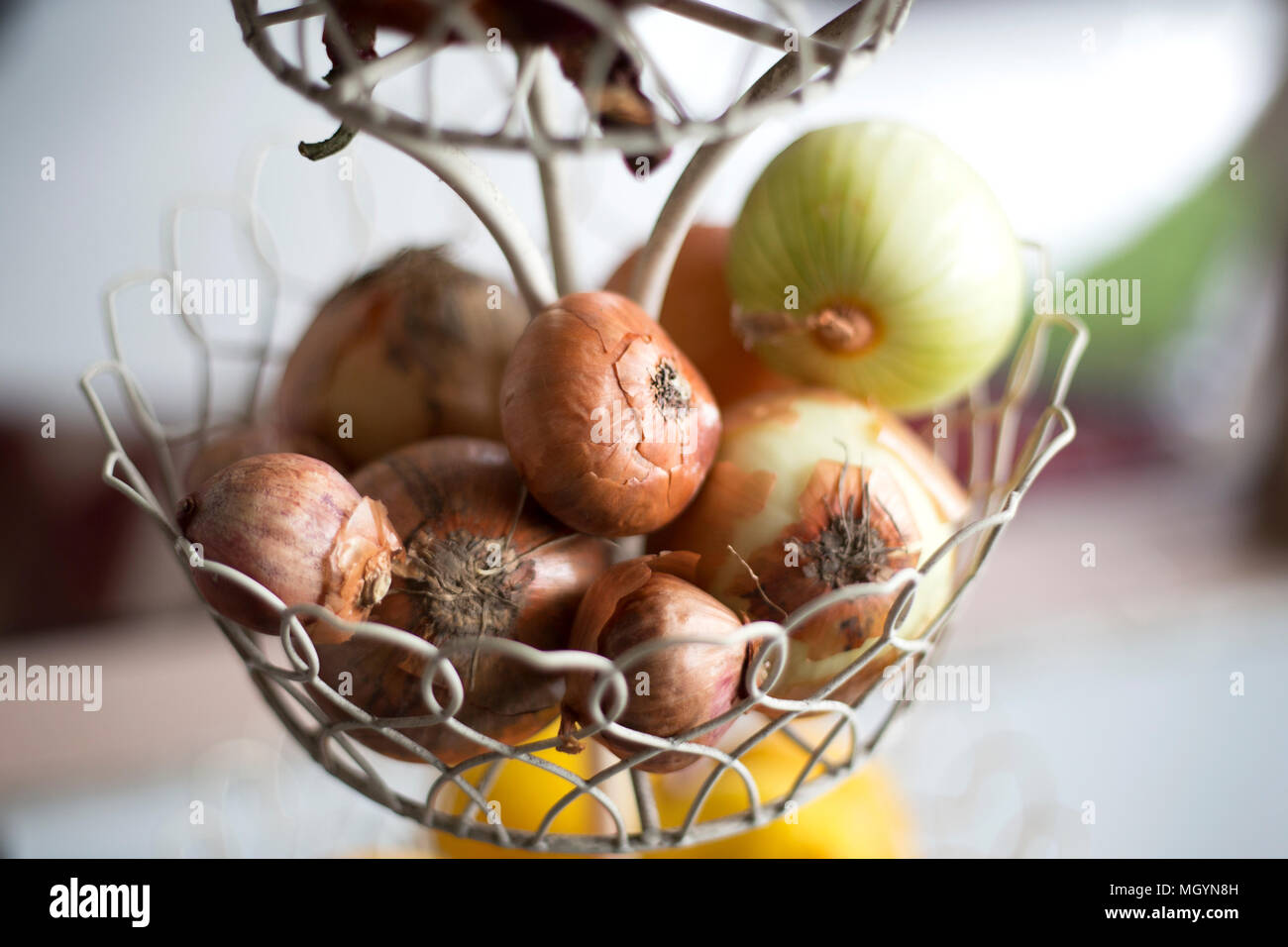 Raw onions in a wire basket Stock Photo Alamy