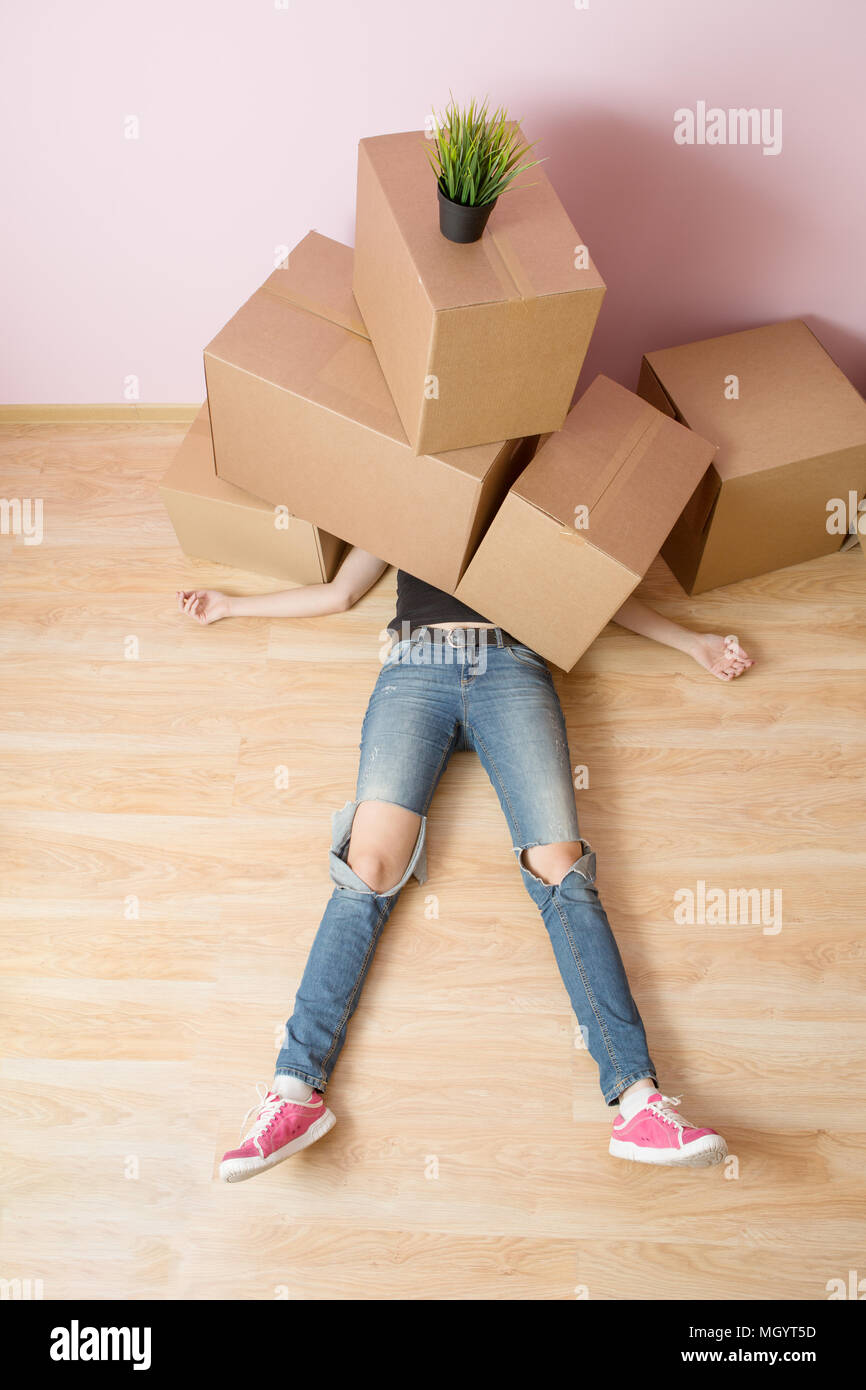 Photo of woman in jeans lying under cardboard boxes Stock Photo Alamy