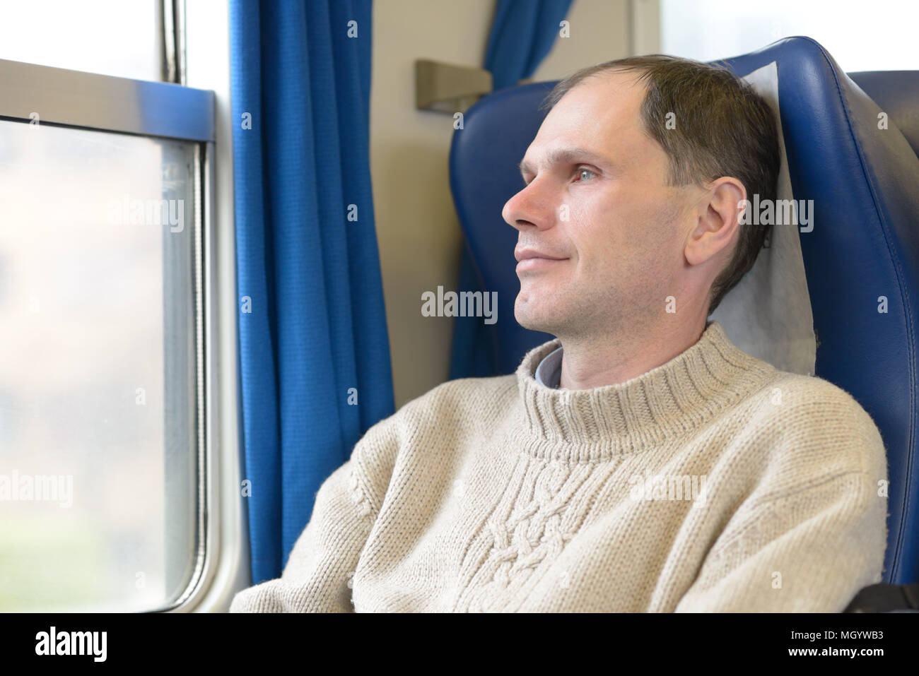 Passenger in a train looking out the window Stock Photo