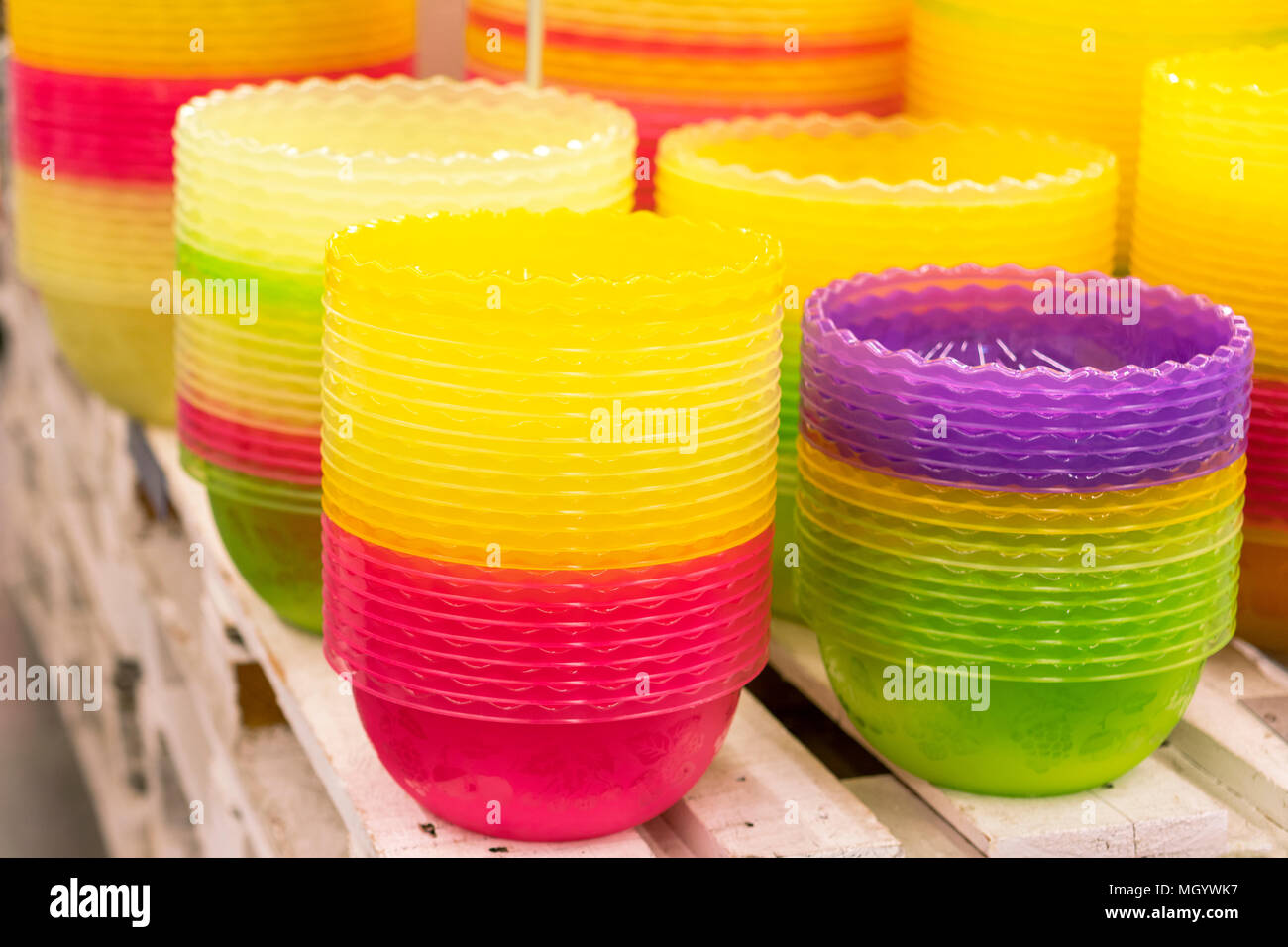 Plastic multi-colored bowls on the shelf in the store. Stock Photo