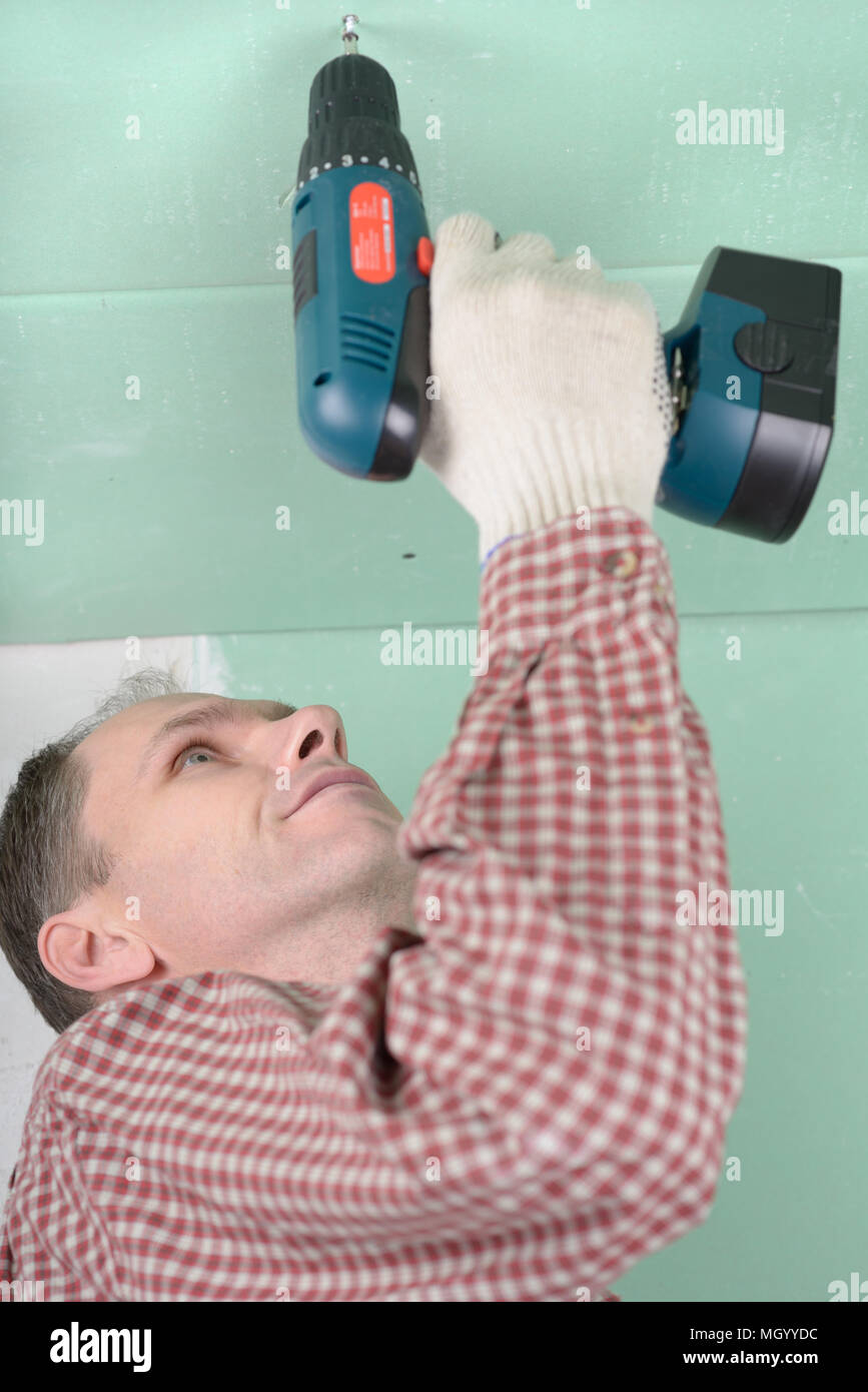 Man installing drywall using cordless drill Stock Photo Alamy