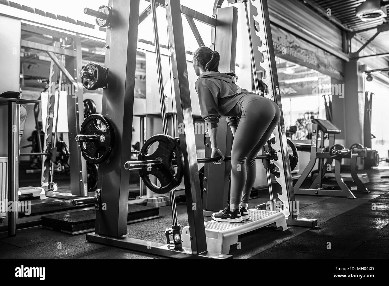 Athletic young woman doing deadlift exercise in the smith machine Stock Photo