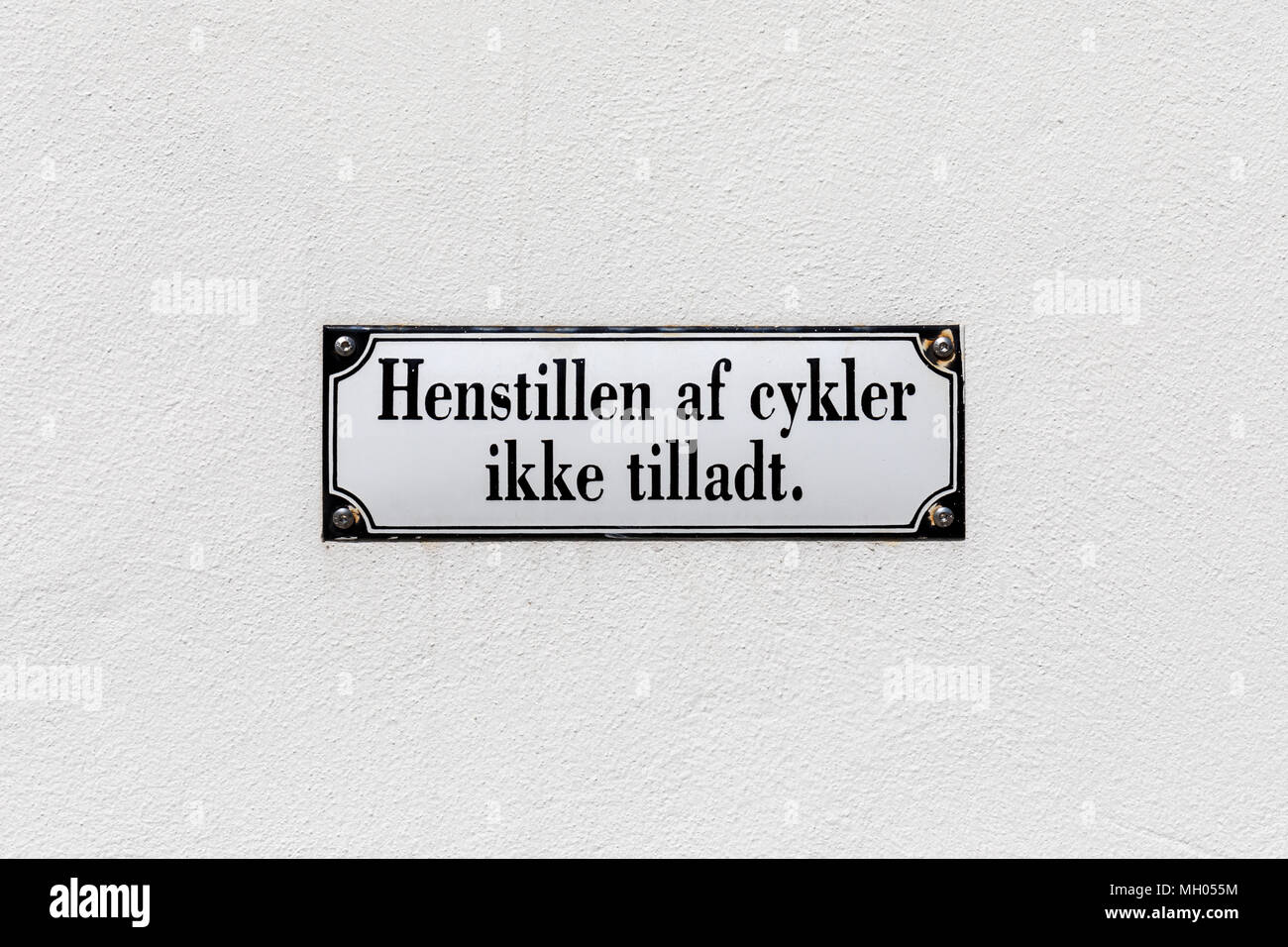 'Henstillen af cykler ikke tilladt' sign on a wall (Danish: 'No bicycle parking') Stock Photo