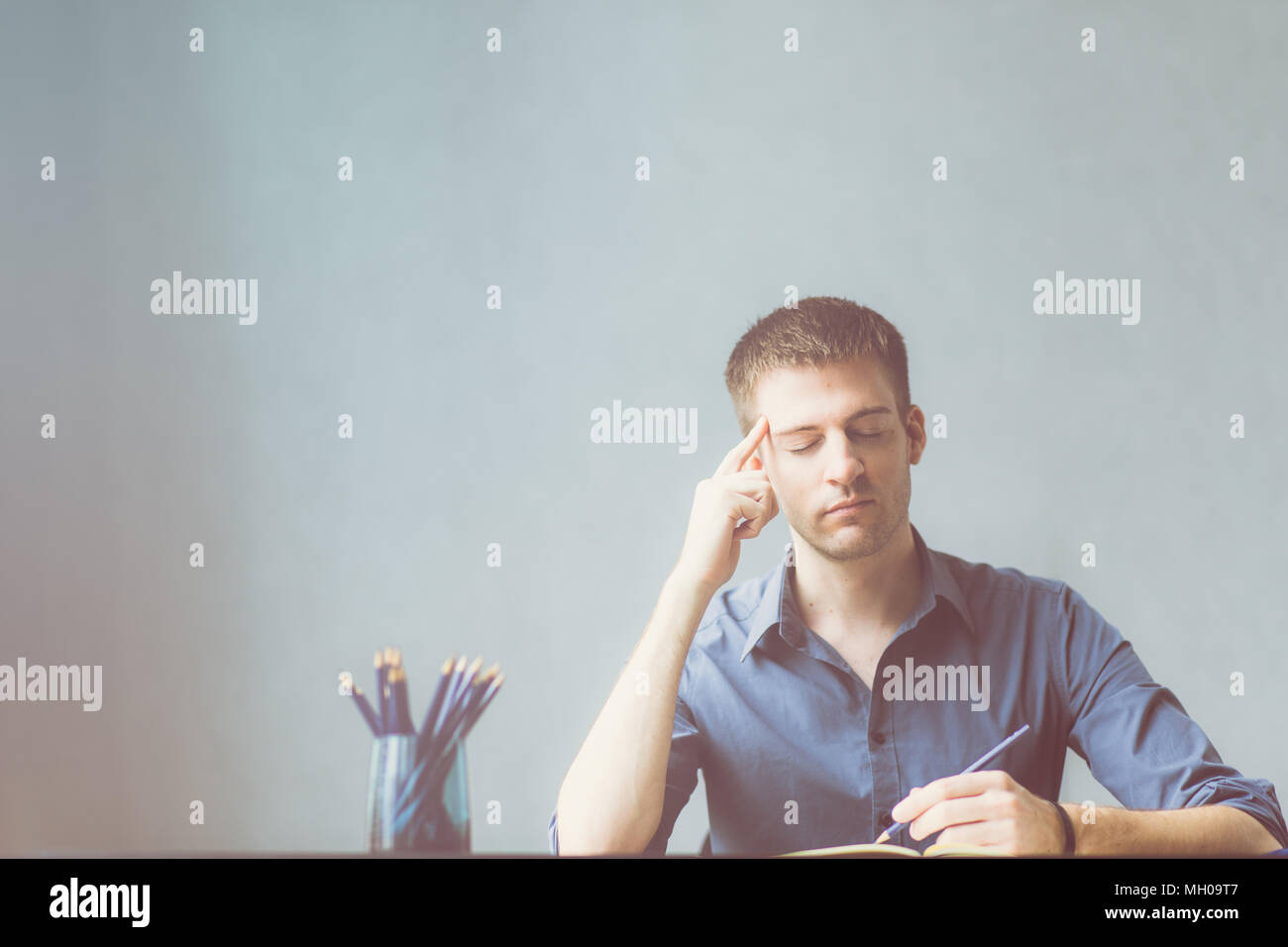 Caucasians businessman wearing a blue shirt stressed out at work office. Headache in planning to successful and growth business. Terrified and nervous Stock Photo