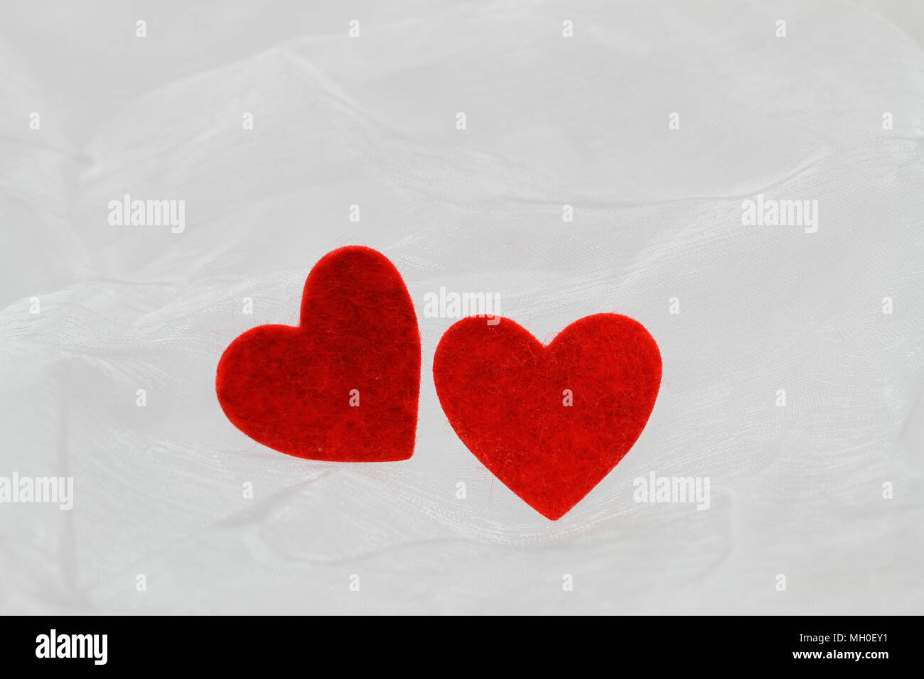 Two red hearts on white cloth with copy space Stock Photo - Alamy