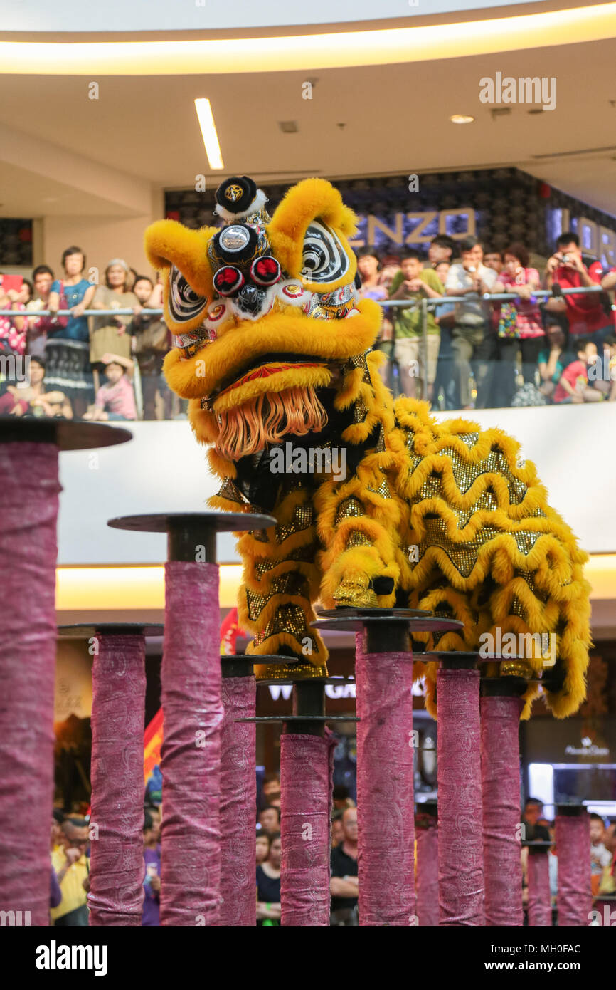 Yellow color lion dance performing on high poles at VIVA HOME shopping