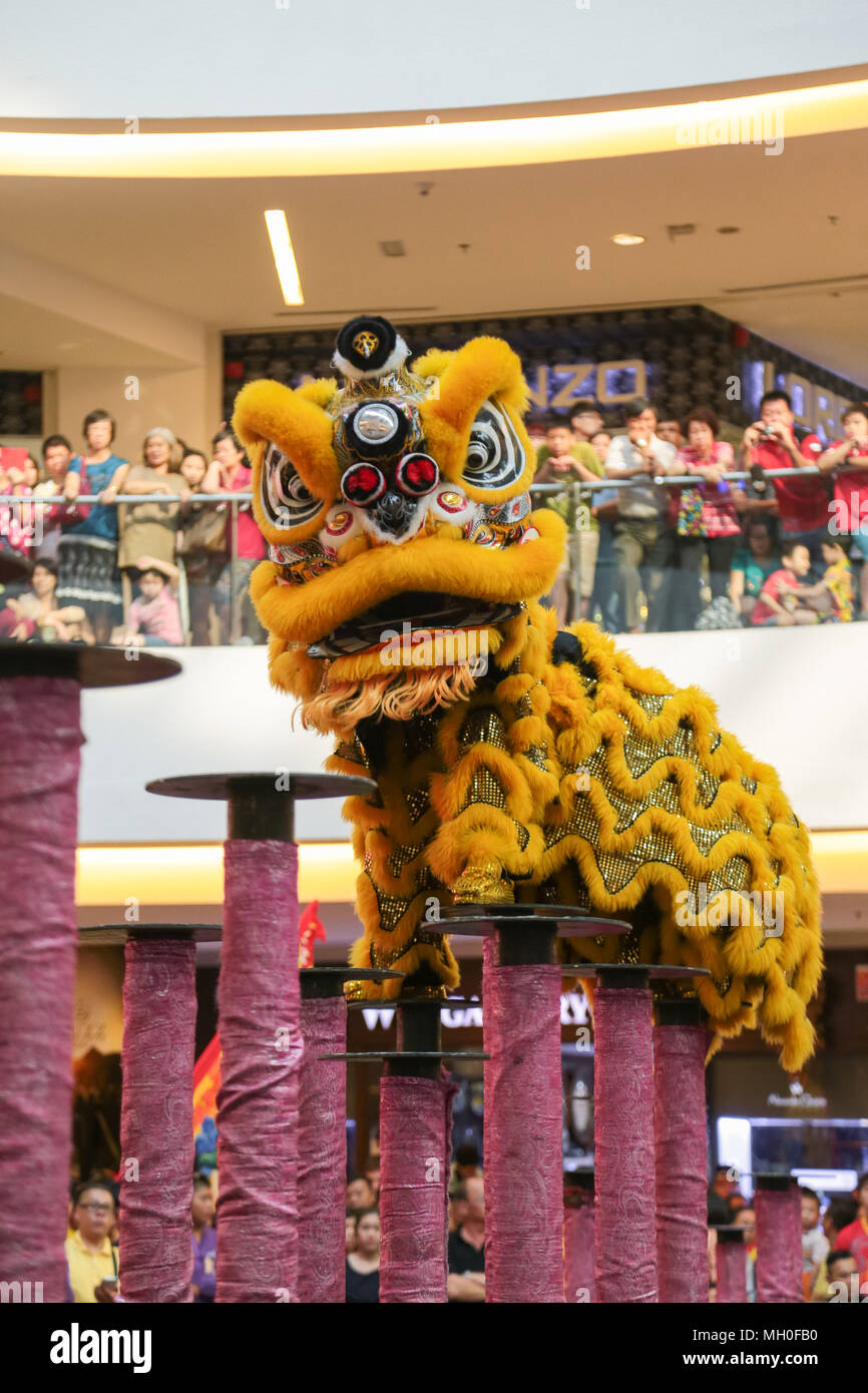 Yellow color lion dance performing on high poles at VIVA HOME shopping