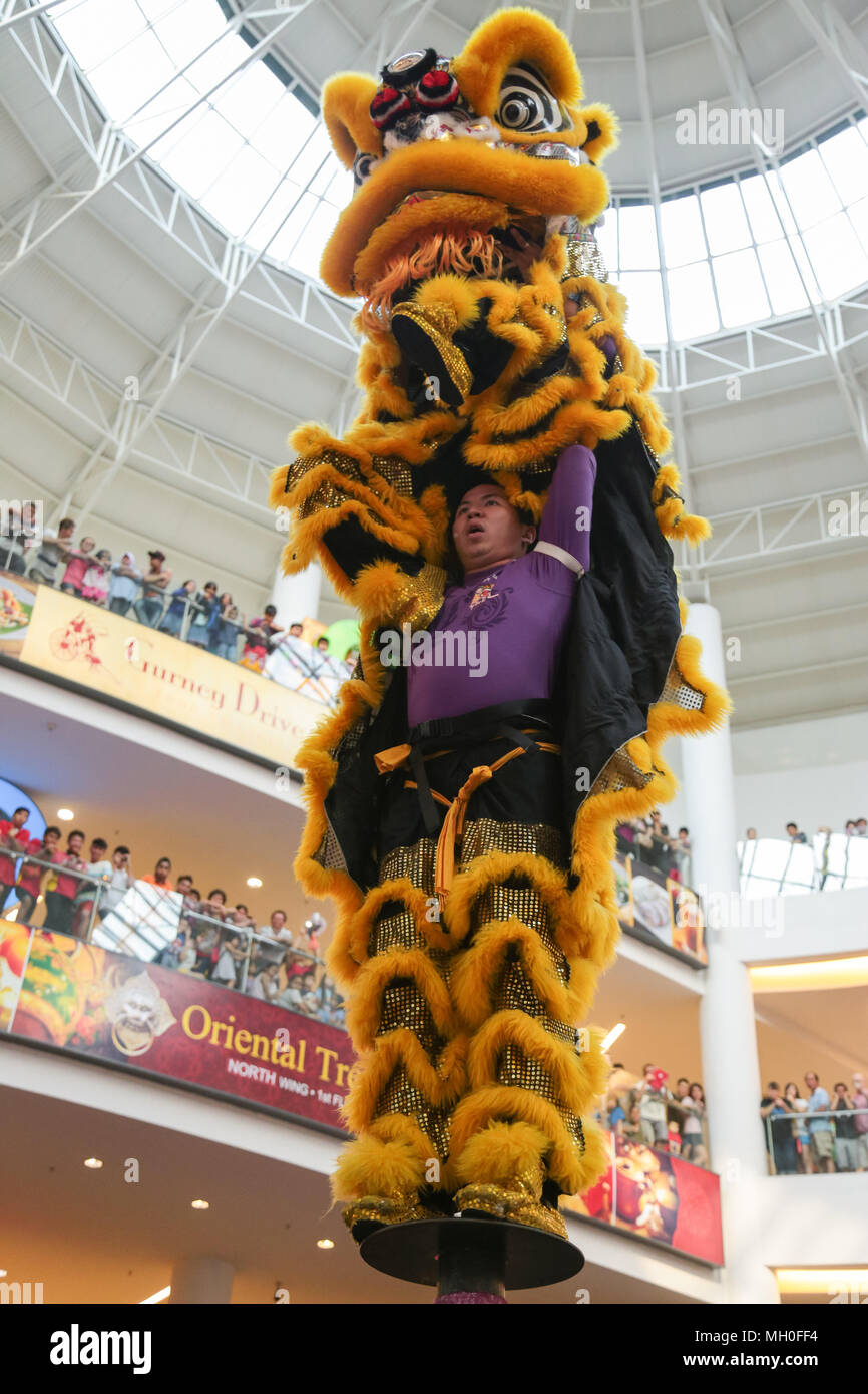 Yellow color lion dance performing on high poles at VIVA HOME shopping