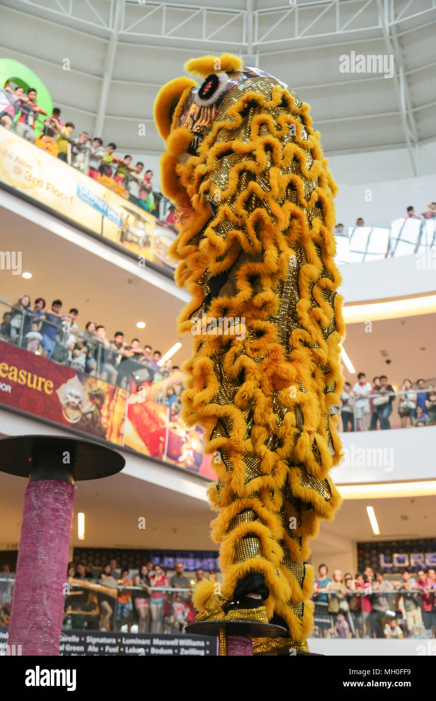 Yellow color lion dance performing on high poles at VIVA HOME shopping mall in Kuala Lumpur, Malaysia. Stock Photo