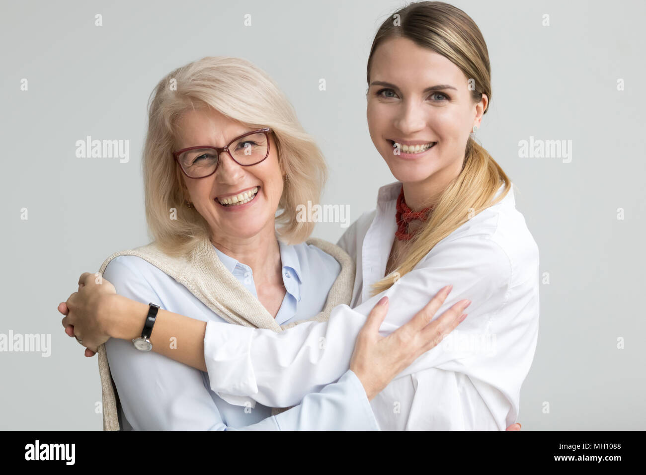 Happy senior older mother and young daughter laughing embracing Stock