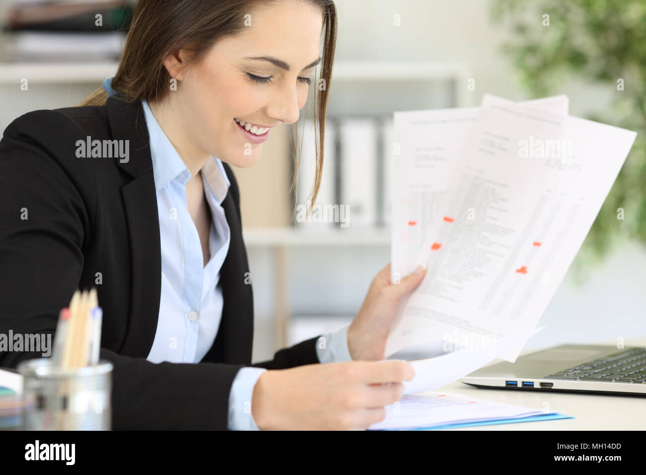 Happy executive working managing different documents at office Stock Photo