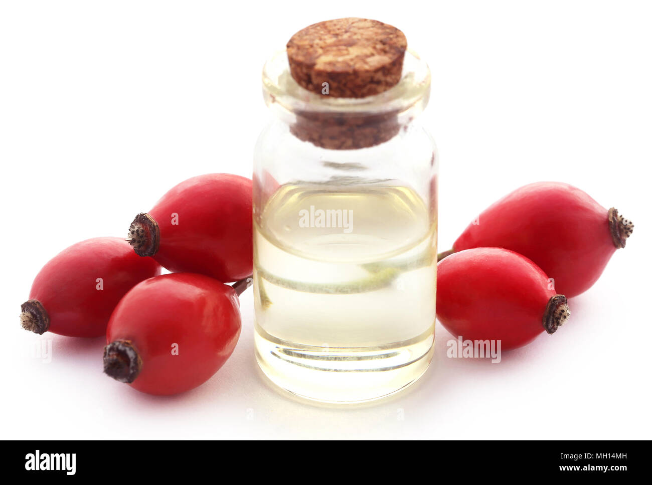 Medicinal Rose hips with essential oil in a glass bottle Stock Photo ...