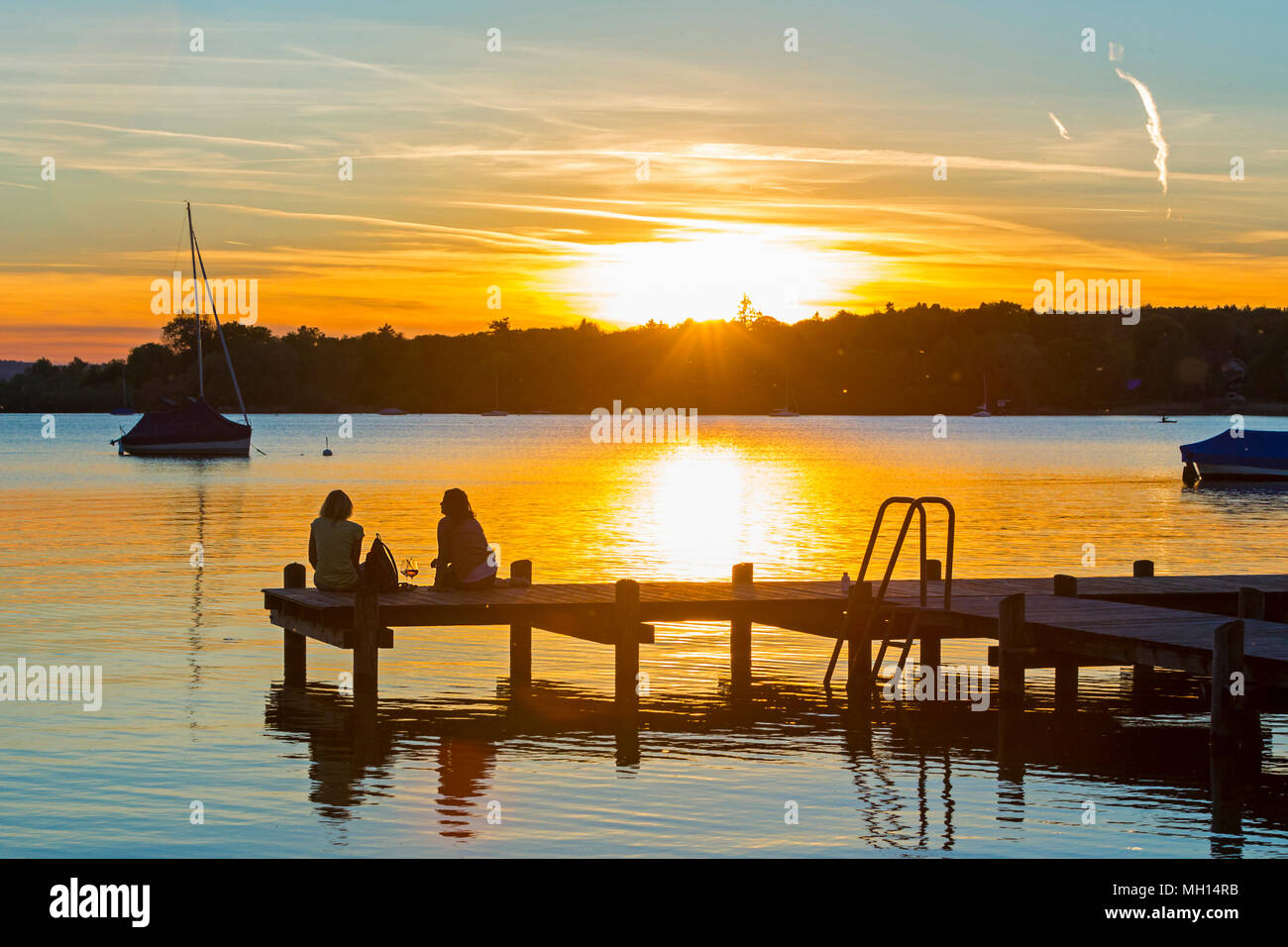 Zwei Frauen am See geniessen den Sonnenuntergang Stock Photo