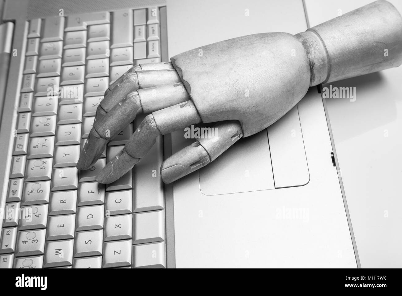 Futuristic robot hand typing and working with laptop keyboard. Mechanical arm with computer Stock Photo