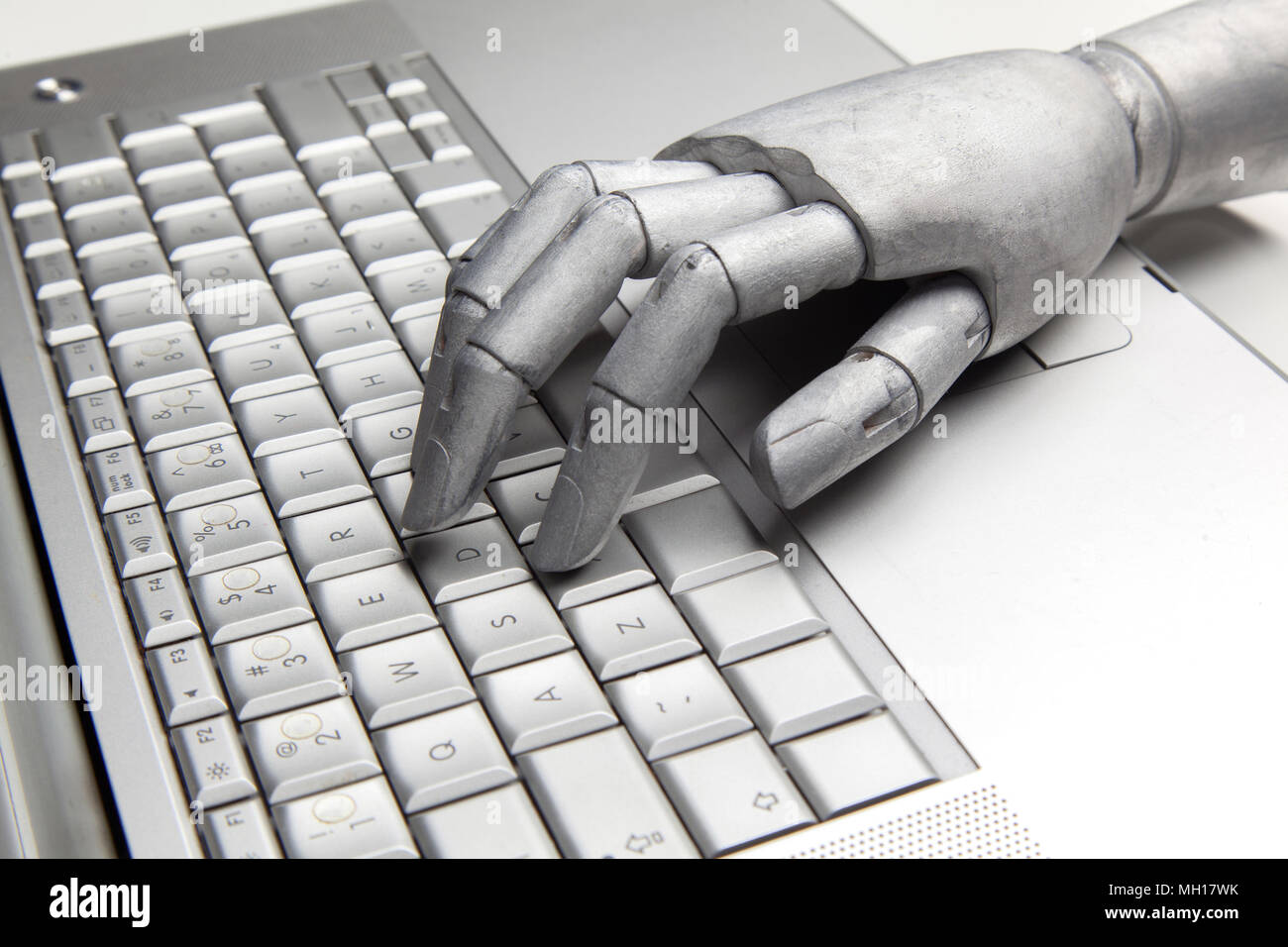 Futuristic robot hand typing and working with laptop keyboard. Mechanical arm with computer Stock Photo