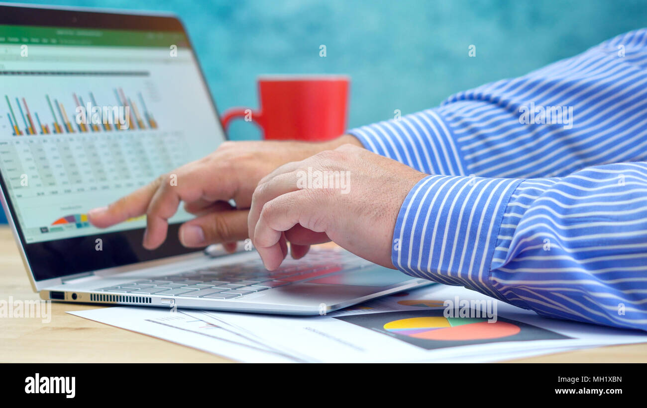 Businessman pointing and expanding graphs on modern touch screen ...
