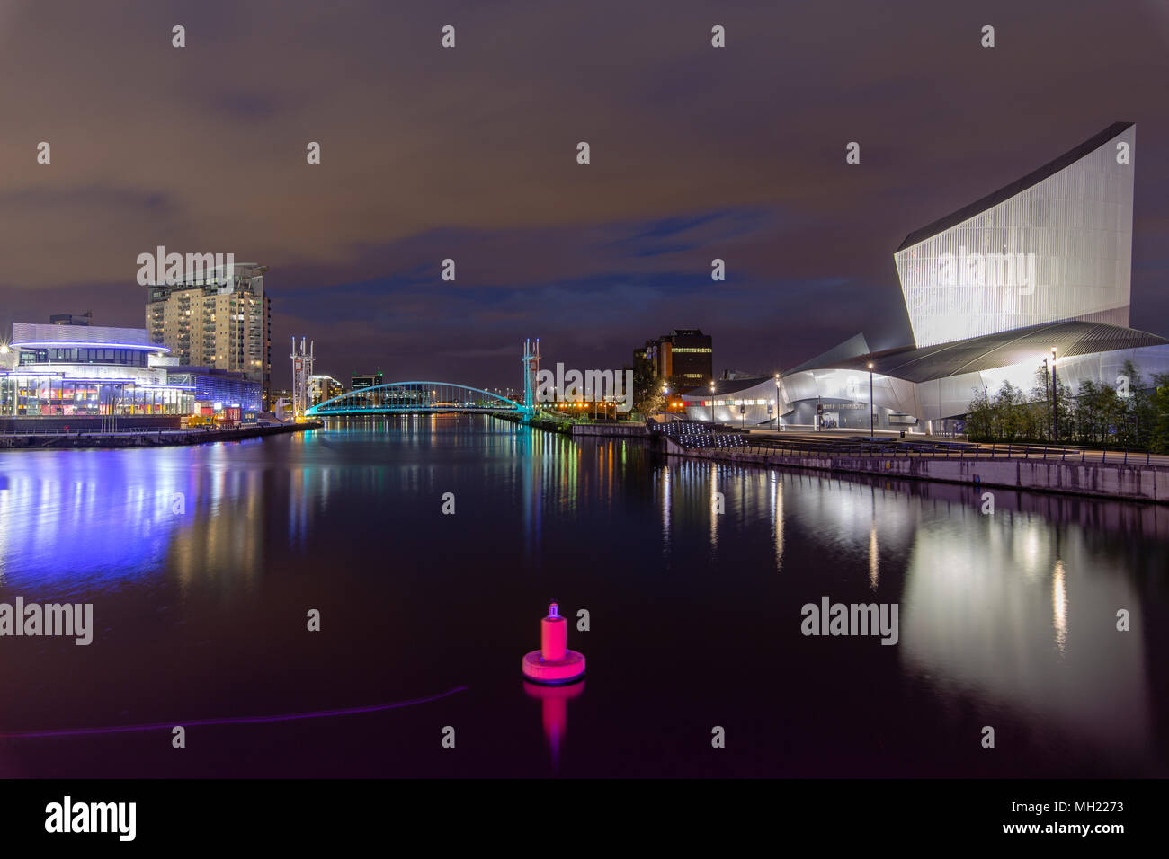 Night view of The Lowry Theatre & galleries, Imperial point building, Millenium lift foot bridge and Imperial war museum at Salford Quays, Trafford, G Stock Photo