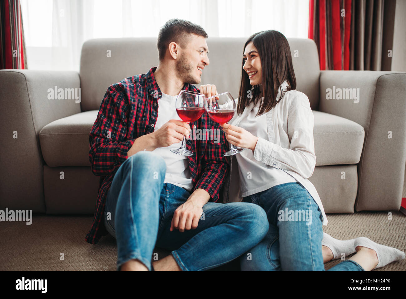 Love couple watches movie and drinks red wine Stock Photo