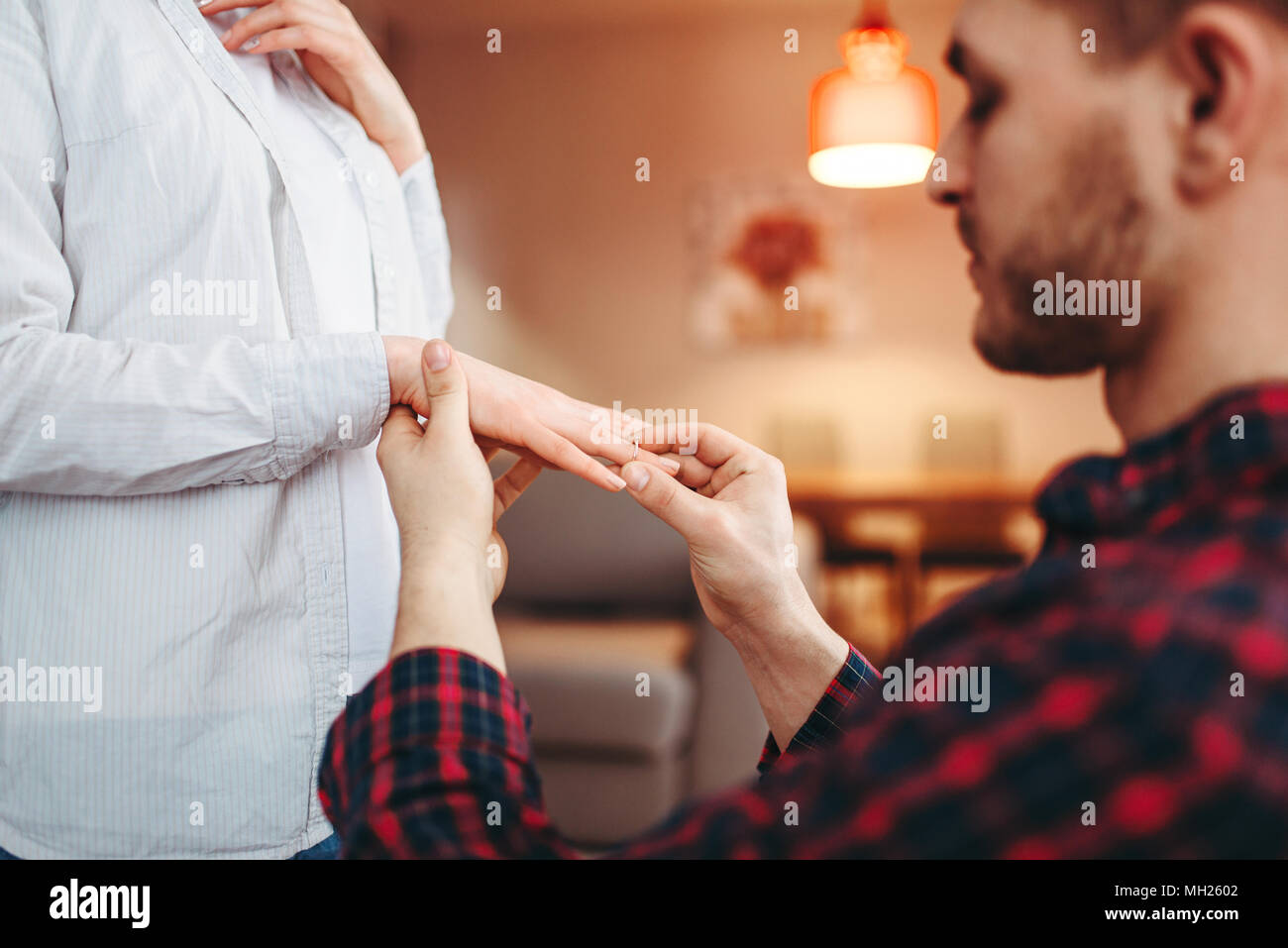 Man puts the wedding ring on the finger of beloved Stock Photo