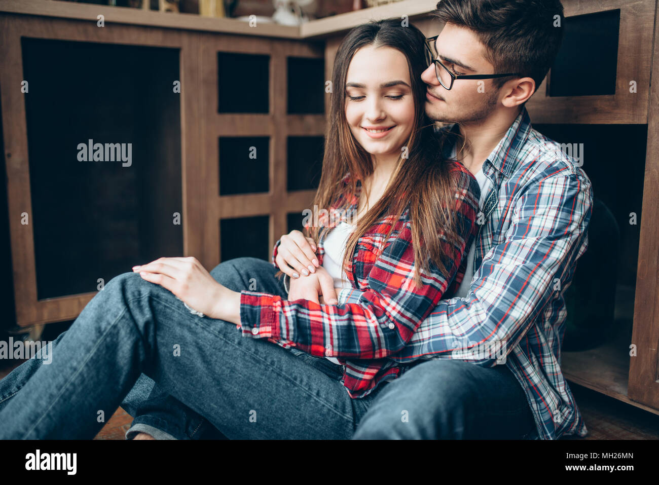 Love couple sitting on the kitchen floor and hugs Stock Photo - Alamy