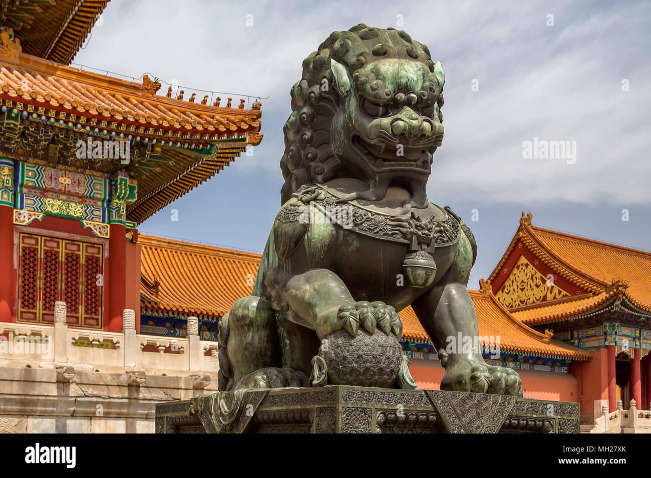 Bronze male lion guarding the Gate of Supreme Harmony. One paw rests on a globe symbolising imperial power over the world. Forbidden City, Beijing. Stock Photo