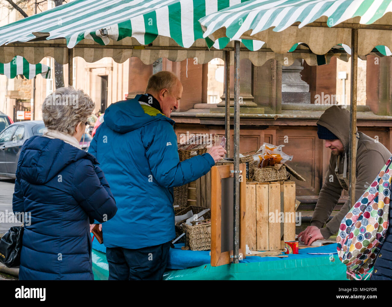 Man buying at outdoor market stall, Haddington Farmers Market, Place d'Aubigny, Court Street, East Lothian, UK Stock Photo