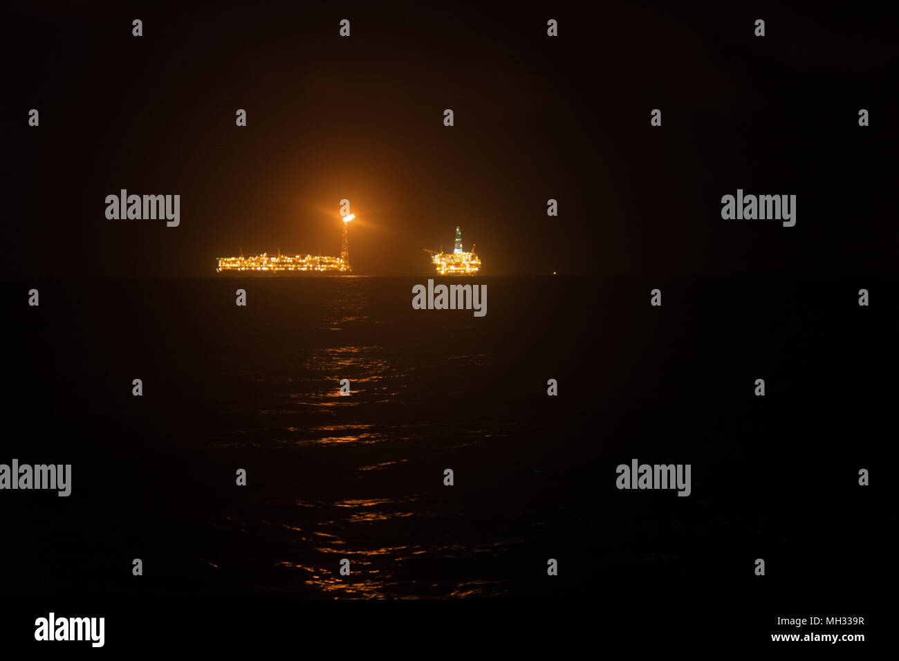 FPSO tanker vessel near Oil Rig at night. Offshore oil and gas industry ...